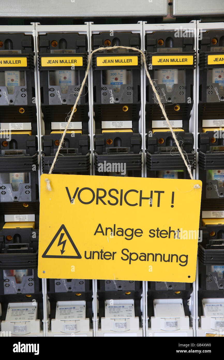 Warning Sign, Caution System is under voltage electrical switchboard, Germany Stock Photo