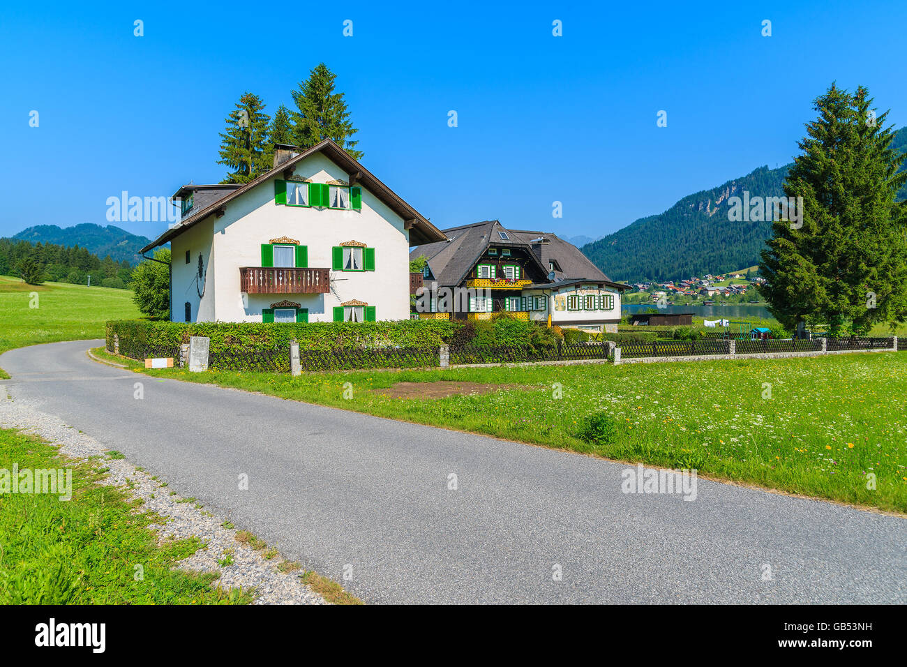 Typical houses along road in countryside landscape of Alps Mountains in summer landscape of Weissensee lake, Austria Stock Photo