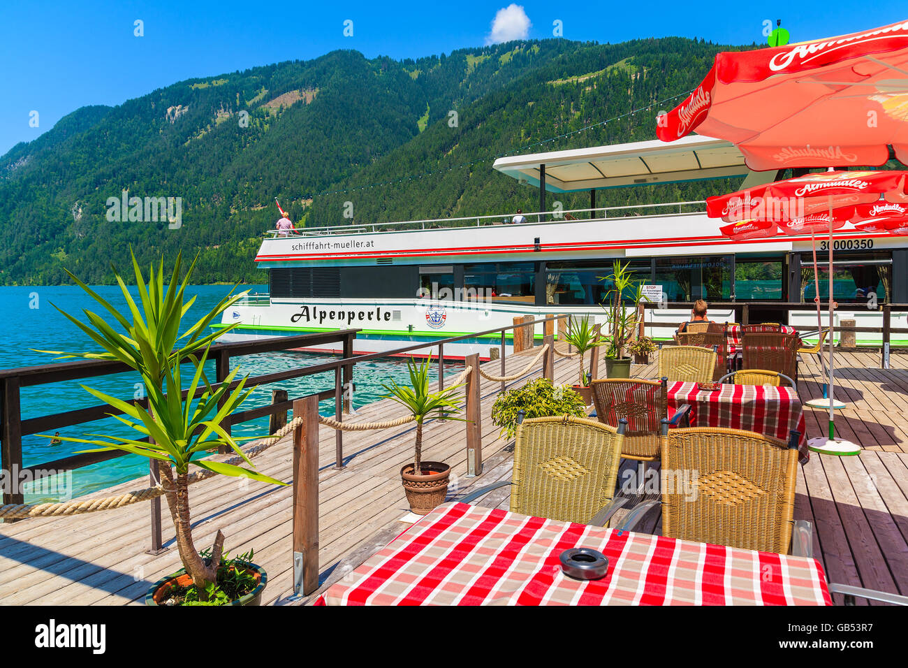 WEISSENSEE LAKE, AUSTRIA - JUL 7, 2015: restaurant on shore of Weissensee lake in summer time. 'Alpine Pearl' tourist boat has d Stock Photo