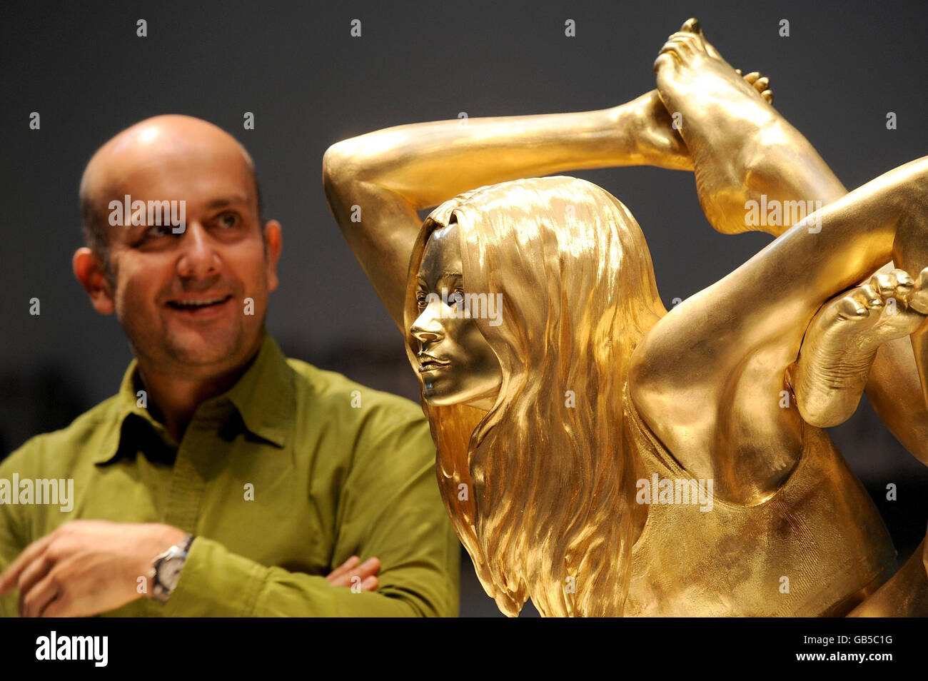 Marc Quinn with his 50kg solid gold statue of supermodel Kate Moss in a yogic pose called 'Siren' is unveiled at the opening of the 'Statuephilia' exhibition at the British Museum in London. Stock Photo