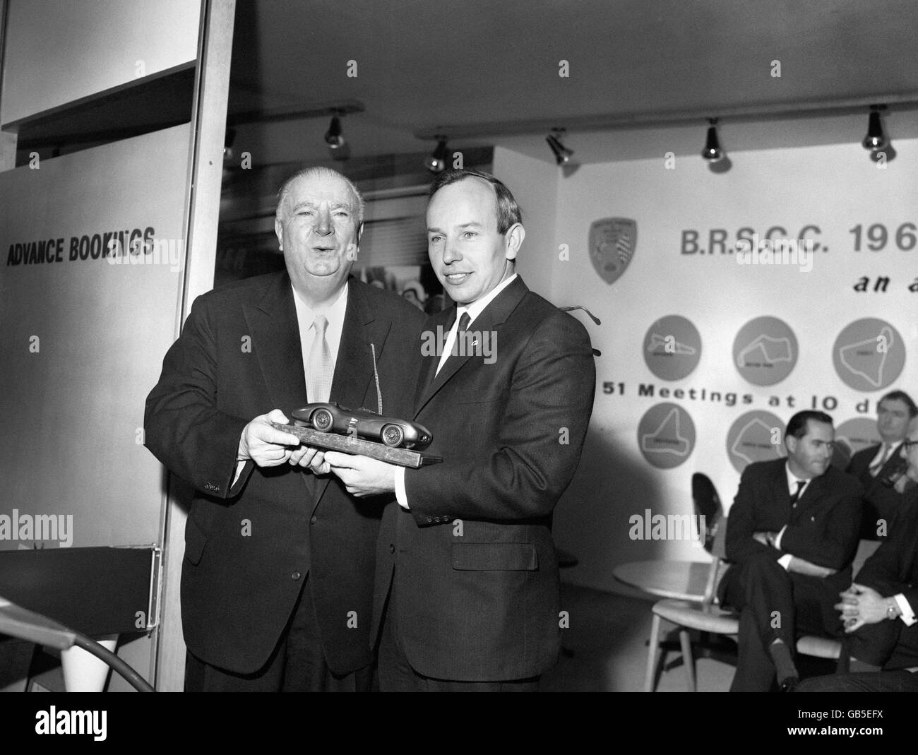 Alfred Neubauer presents a trophy of a racing car to John Surtees. Stock Photo