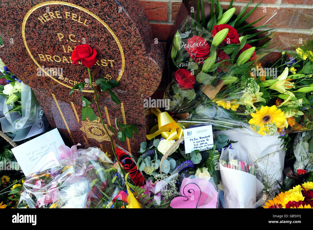 A memorial dedicated to PC Ian Broadhurst is surrounded by flowers including a message from Prime Minister Gordon Brown (right) after the memorial unveiling ceremony in Dib Lane in Leeds. Stock Photo