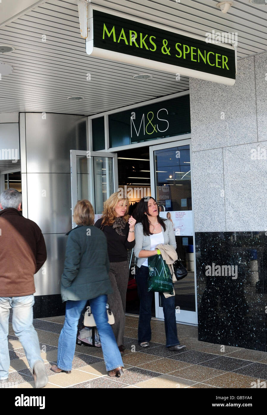 M&S to cut back spending plans. Customers leave a Marks & Spencers store in York. Stock Photo