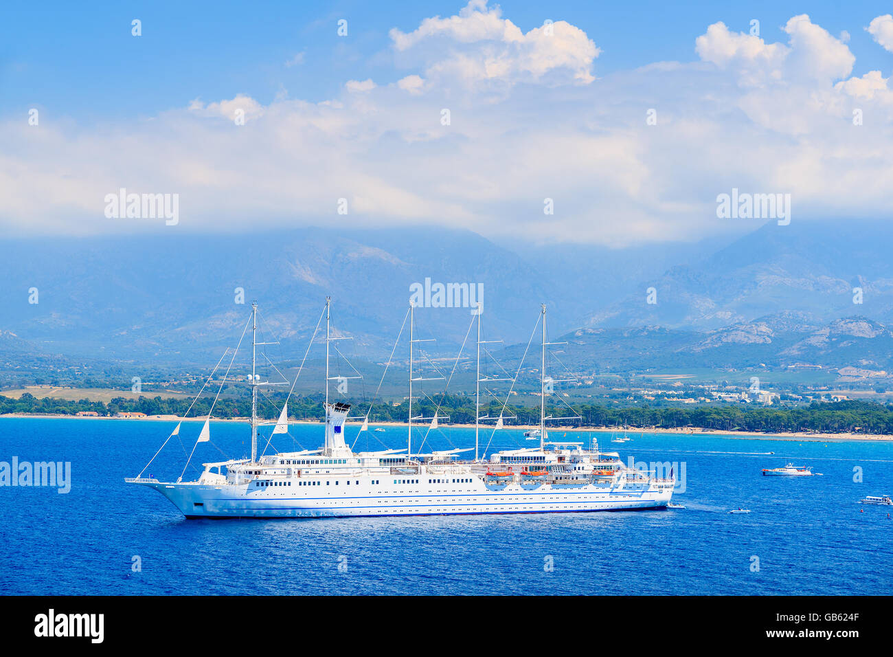 View of cruise ship mooring on blue sea in Calvi bay, Corsica island, France Stock Photo