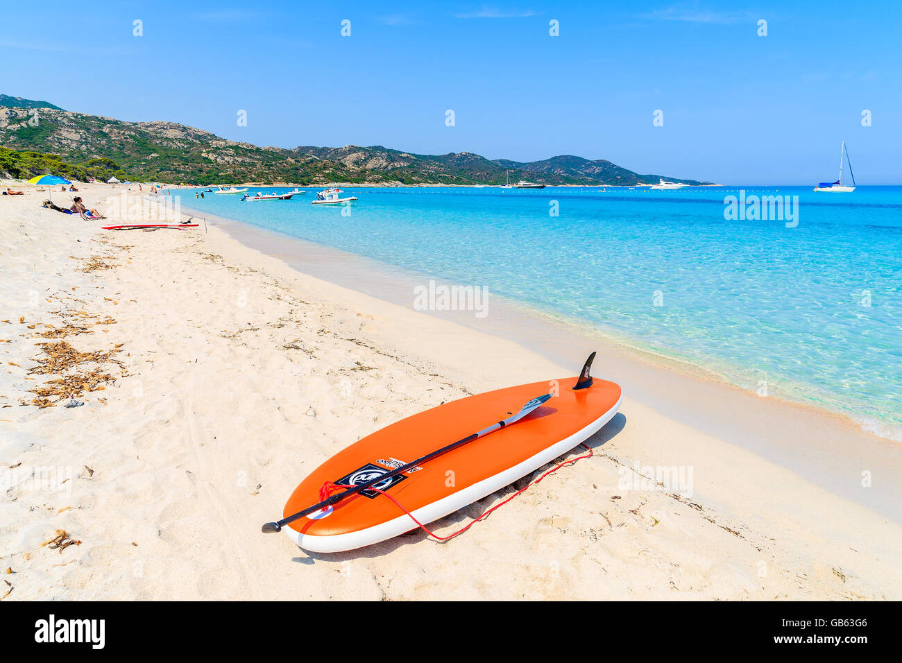 SALECCIA BEACH, CORSICA ISLAND - JUL 3, 2015: surfing board on sandy shore of idyllic Saleccia beach, Corsica island, France. Stock Photo