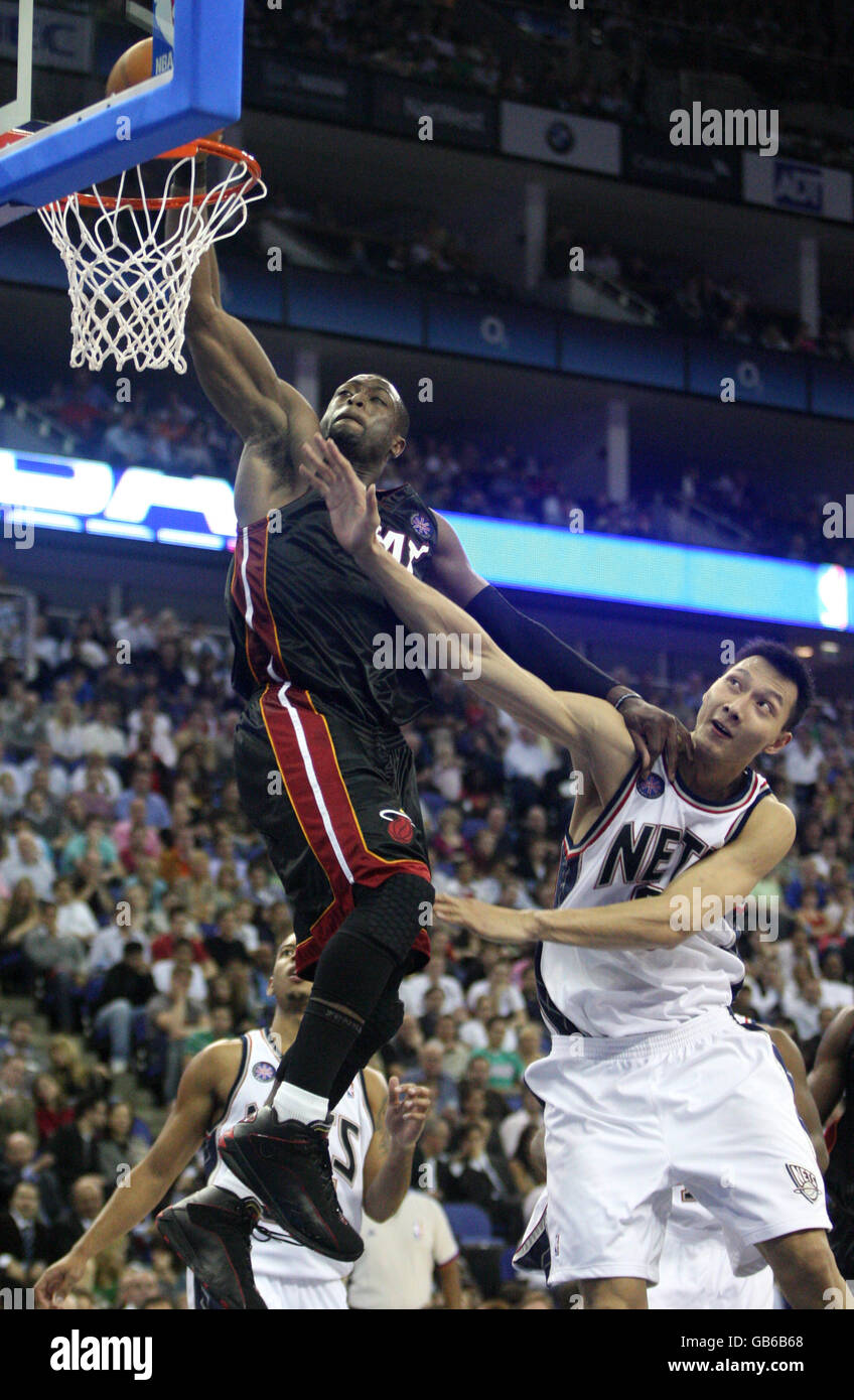 Basketball - NBA - Pre-Season Tour - Miami Heat v New Jersey Nets - O2 Arena. Miami Heat's Dwayne Wade dunks to score despite pressure from New Jersey Net's Yi Jianlian Stock Photo