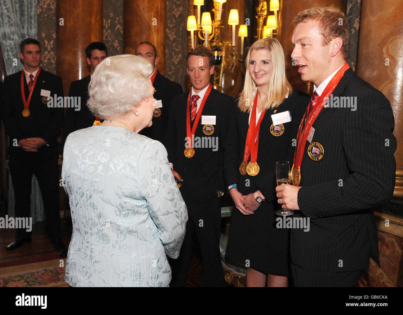 Britain's Queen Elizabeth II meets Olympic medalists Chris Hoy (right) and Rebecca Adlington (centre right) during the Beijing Olympics Team GB reception at Buckingham Palace in London. Stock Photo