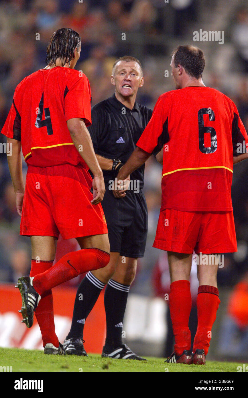 Soccer - European Championships 2004 Qualifier - Group Eight - Belgium v Croatia. Referee Graham Poll stands up to Belgium's Daniel van Buyten (l) and Philippe Clement (r) Stock Photo