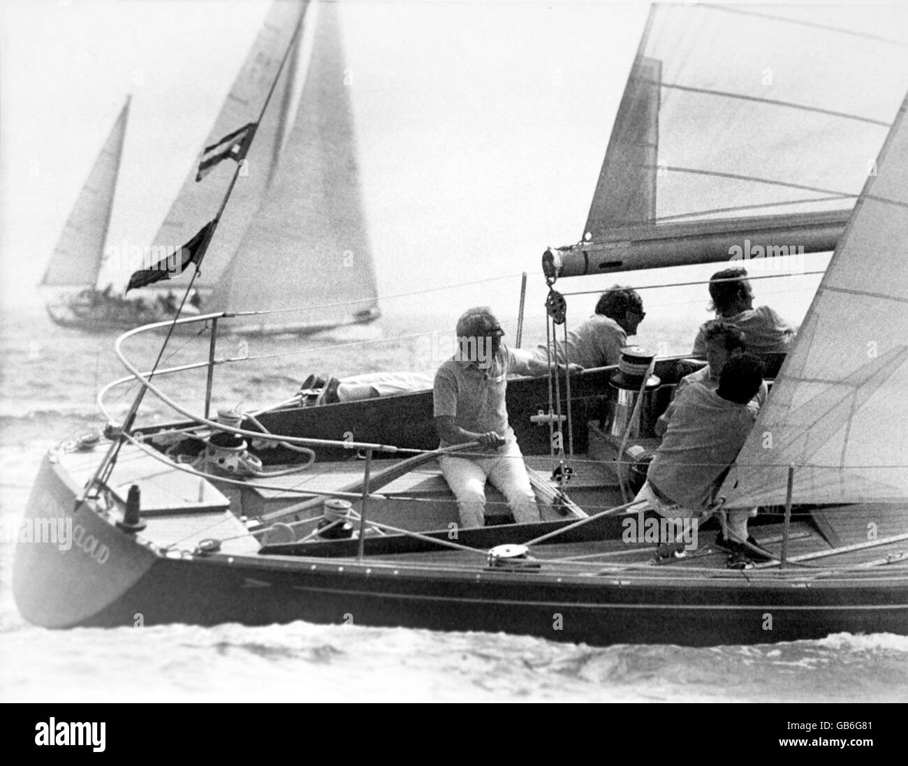 Prime Minister Edward Heath (l) operates the rudder on his yacht, Morning Cloud Stock Photo