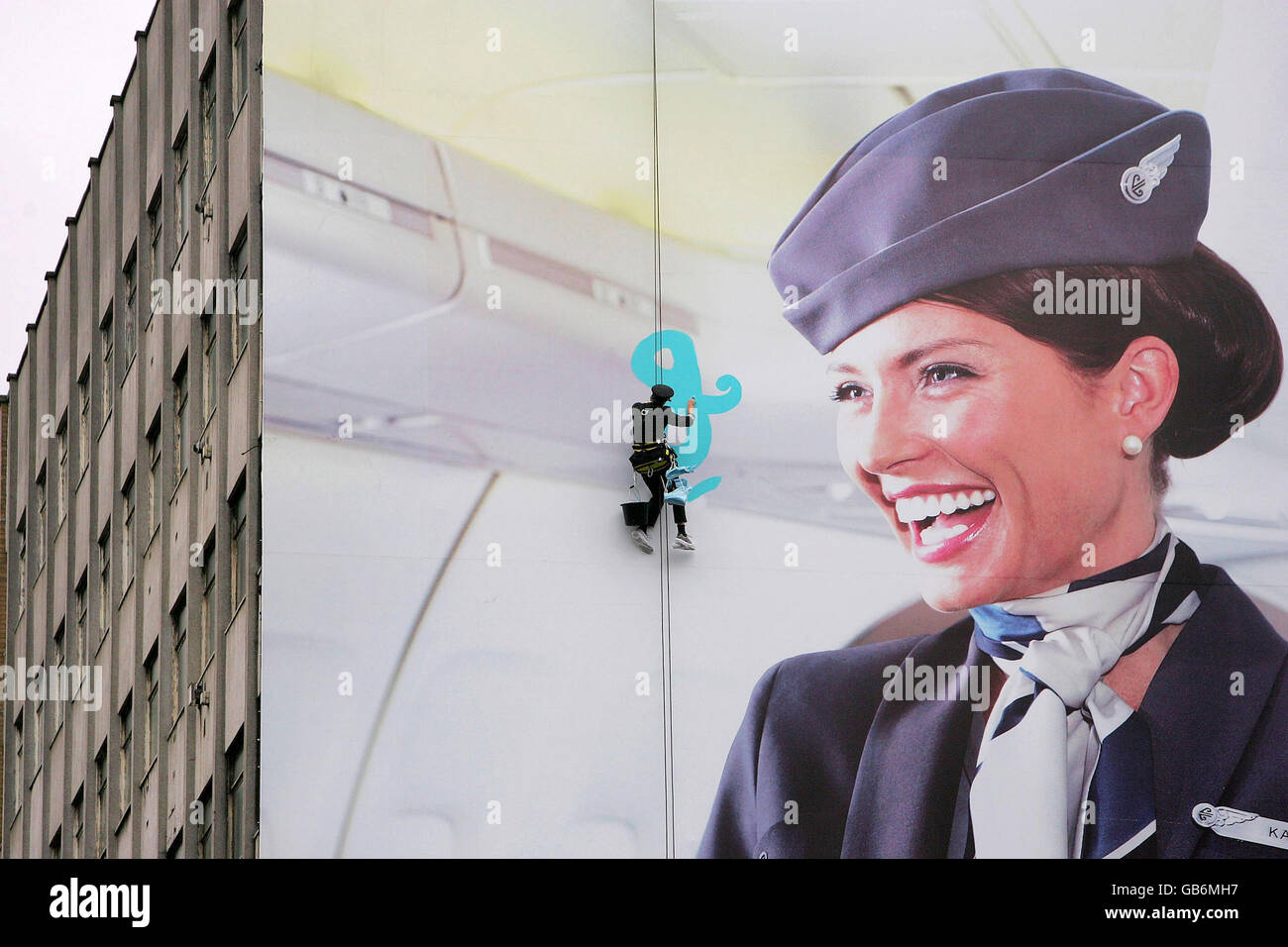 STANDALONE PHOTO Air New Zealand B747 Captain, Peter Clulow, abseils down a billboard to paint the slogan on the poster for the airline's latest advertising campaign in Aldgate, central London. Stock Photo