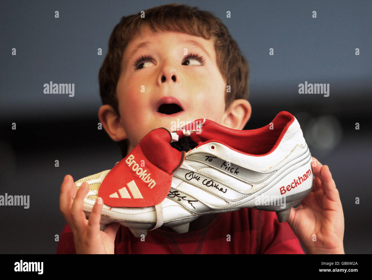 Hugh Convery, 4, holds a football boot belonging to lead singer of