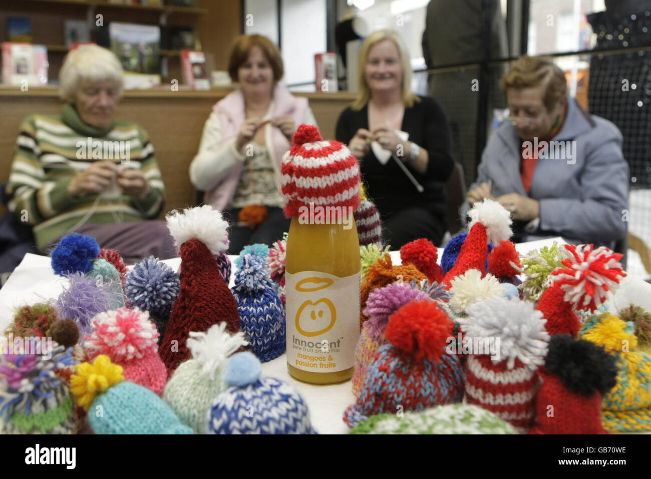 Customers take part in a 'Knit in' at Age Actions shop in Dublin where they are trying to raise euro 20,000 by knitting little wooly hats for Innocent smoothy Bottles. Stock Photo