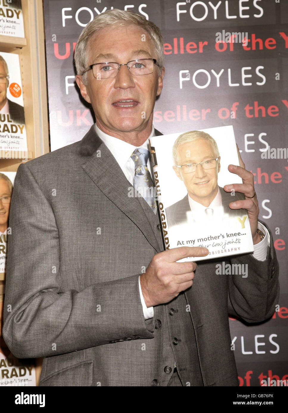 Paul O'Grady holding a copy of his book 'At My Mother's Knee', in