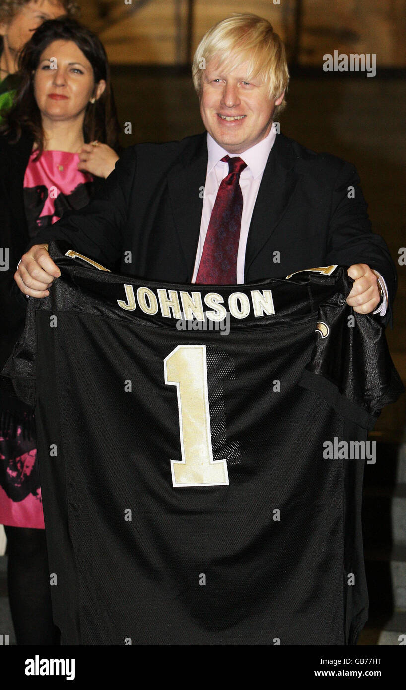 London Mayor Boris Johnson is presented with an New Orleans Saints American football shirt before a gala dinner at St Paul's Cathedral, London. Stock Photo