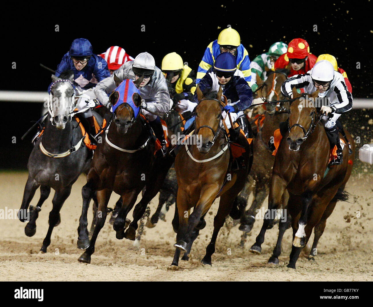 The field come lead by Risky Capital ridden by Hayley Turner (center blue cap) round the final bend during the Epping Forest Claiming during at Great Leighs Racecourse, Chelmsford. Stock Photo