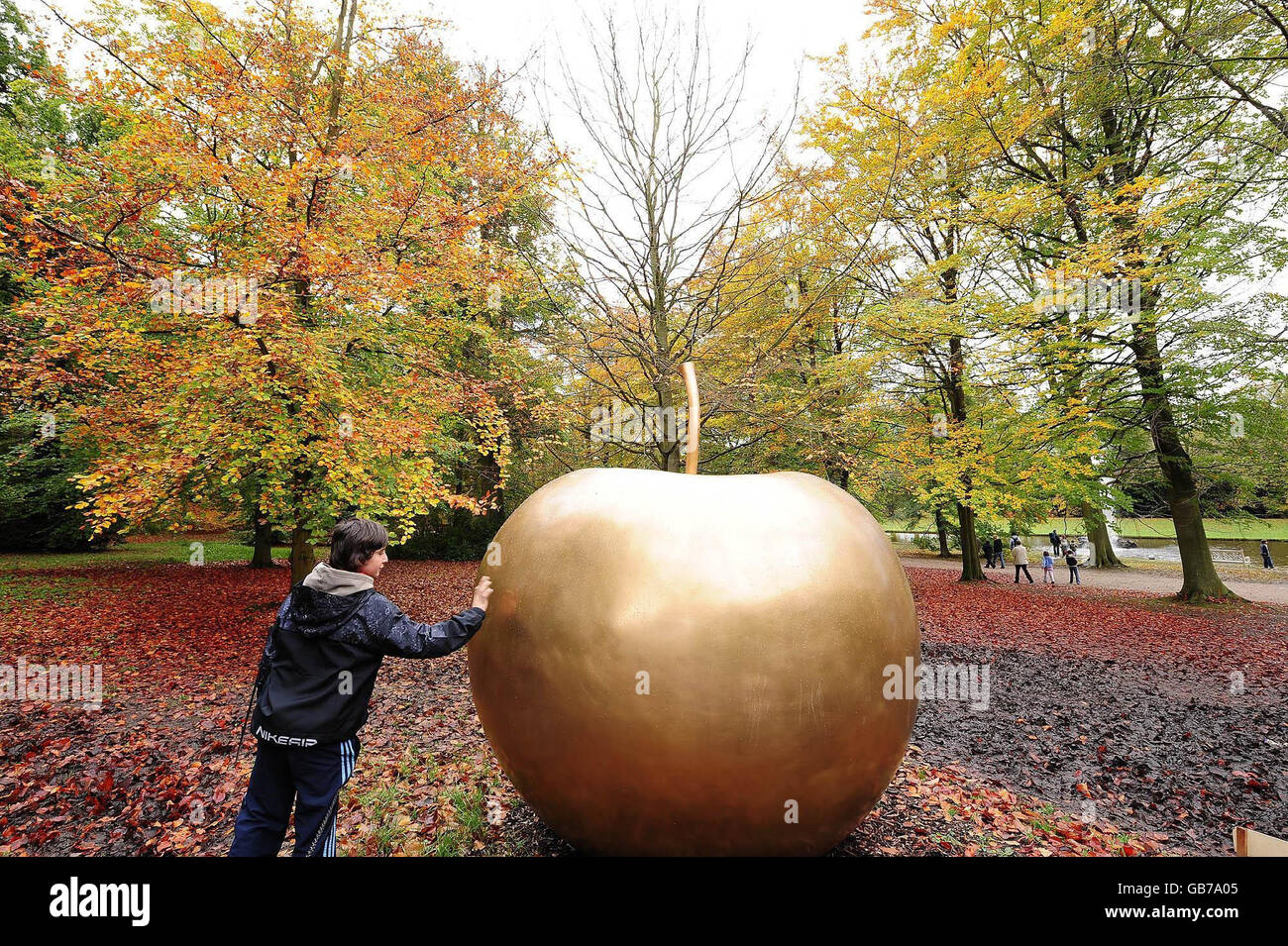 A visitor admires Pomme de New York by Claude Lalanne in the grounds of Chatsworth House in the Peak District. Stock Photo