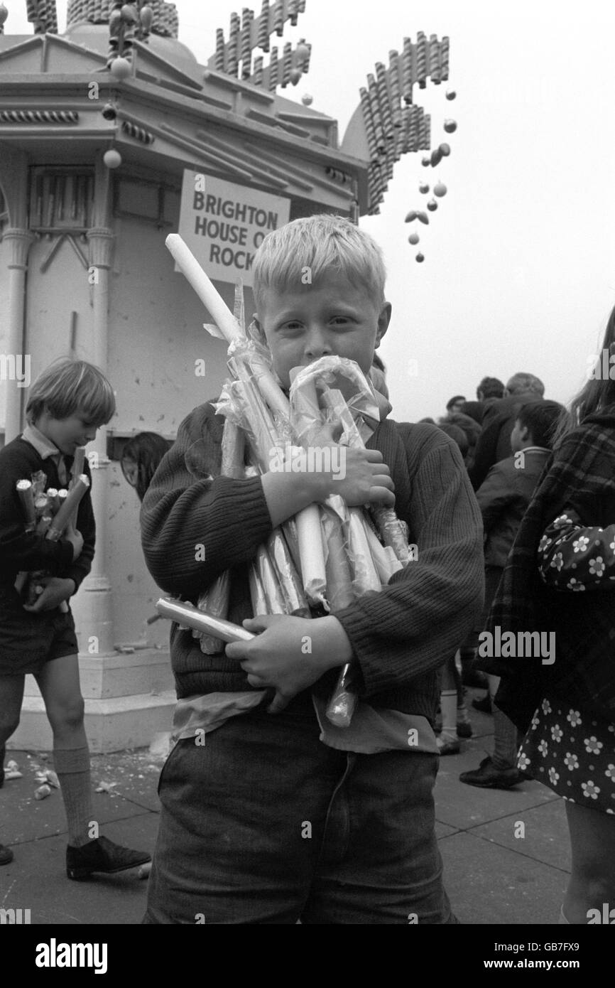 Eight year old Geoff Wiffin of Hove carries off an armful of rock after he joined hundreds of other children in an all out attack on a House of Rock at Brighton. Stock Photo