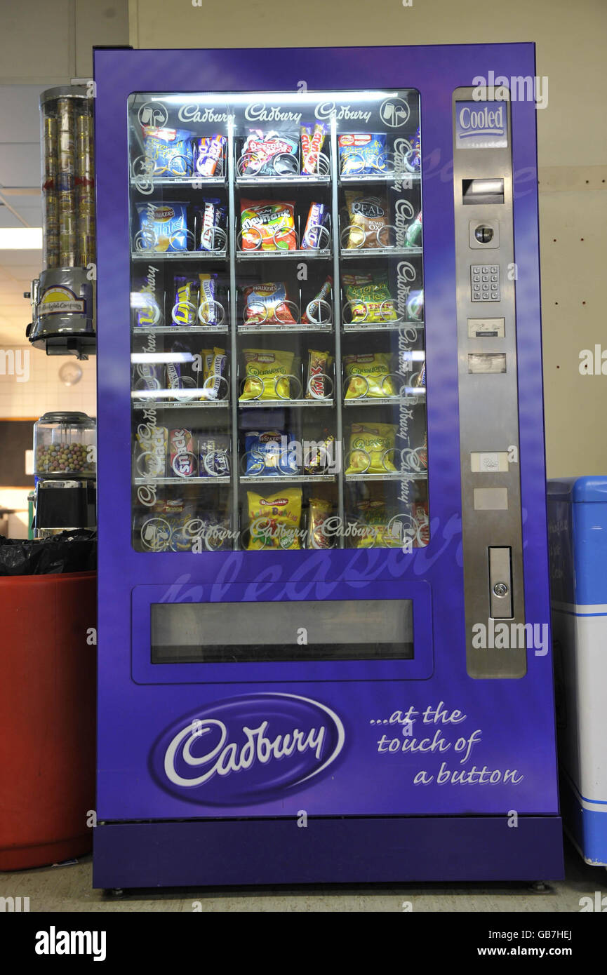 An unhealthy vending machine containing high sugar sweets, chocolate and crisps in a Welsh hospital. Stock Photo