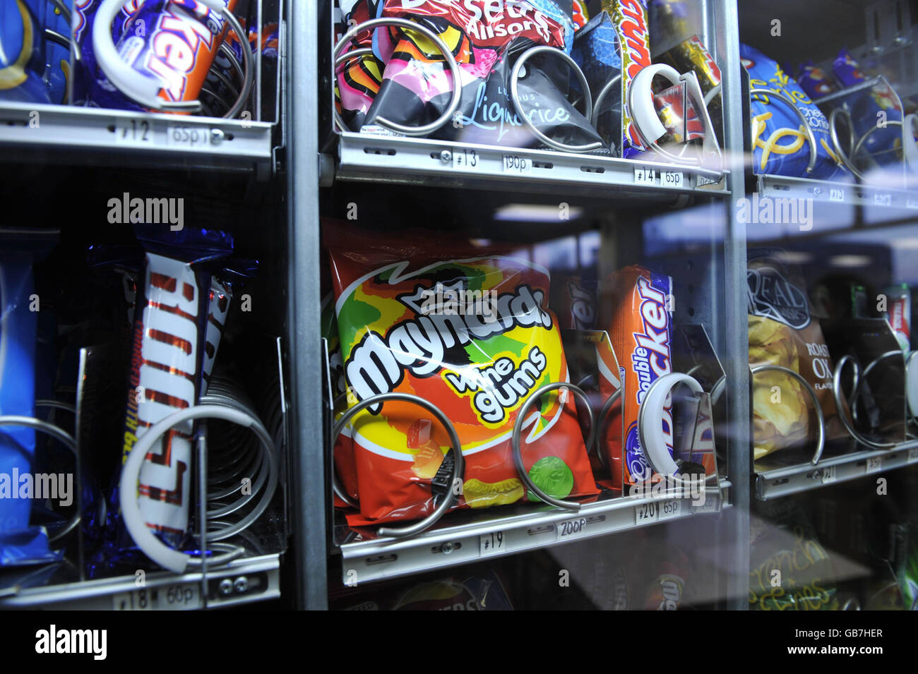 An unhealthy vending machine containing high sugar sweets, chocolate and crisps in a Welsh hospital. Stock Photo
