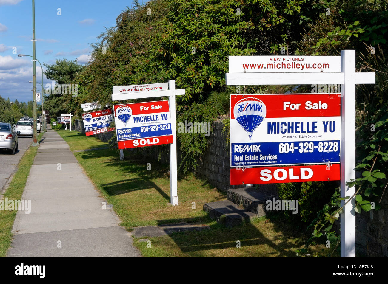 Houses for sale and sold real estate residentialsigns lining a street in Vancouver, British Columbia, Canada Stock Photo