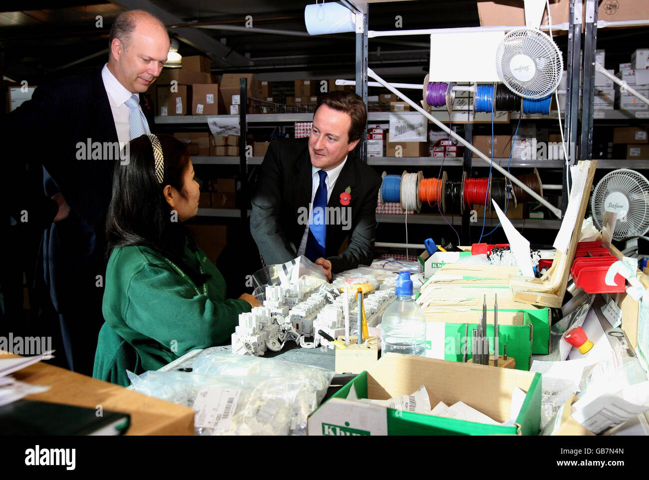 Shadow Work and Pensions secretary Chris Grayling (left) and Conservative Party leader David Cameron (right) chat to assembly technician, Noojan Humphries, during a visit to Routeco plc, in Milton Keynes. Stock Photo