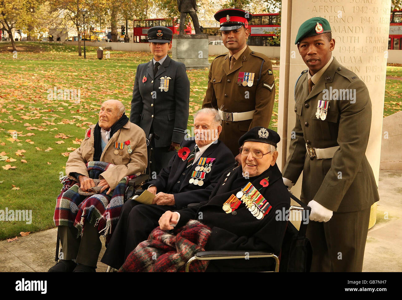 First World War veterans (front L-R) 112 year old Henry Allingham, 110 year old Harry Patch and 108 year old Bill Stone, escorted by Lieutenant Michelle Goodman holder of the Distinguished Flying Cross (back L), Corporal Johnson Beharry, holder of The Victoria Cross, and Marine Mkhuseli Jones, holder of Military Cross (R), gather at the start of the Armistice day commemorations. Stock Photo