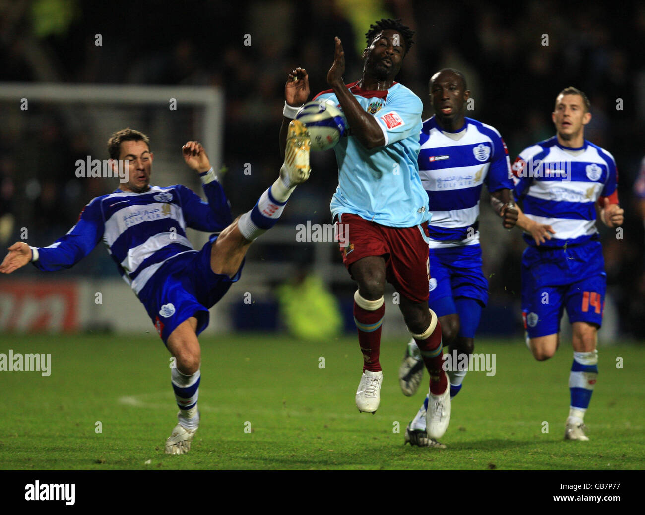 Queens Park Rangers' Lee Cook and Burnley's Ade Akinbiyi battle for the ball during the Coca-Cola Football Championship match at Loftus Road, London. Stock Photo