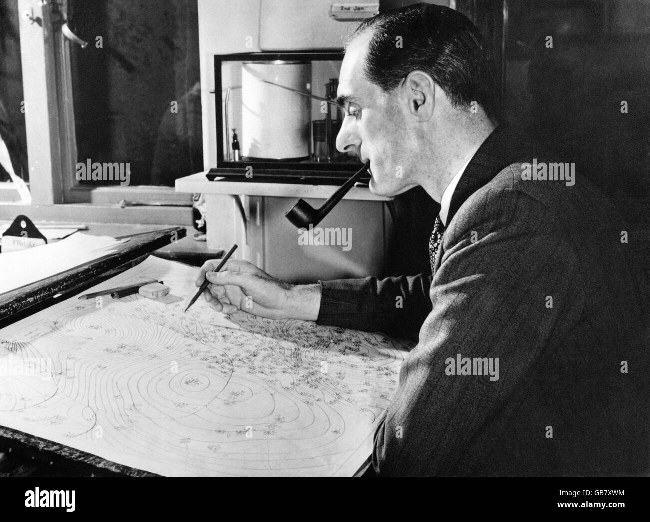George Cowling, one of the two experts chosen by the BBC to brighten TV's presentation of the weather report and forecast, studies a chart at the Meteorological Office in Victory House, Kingsway, London. Stock Photo