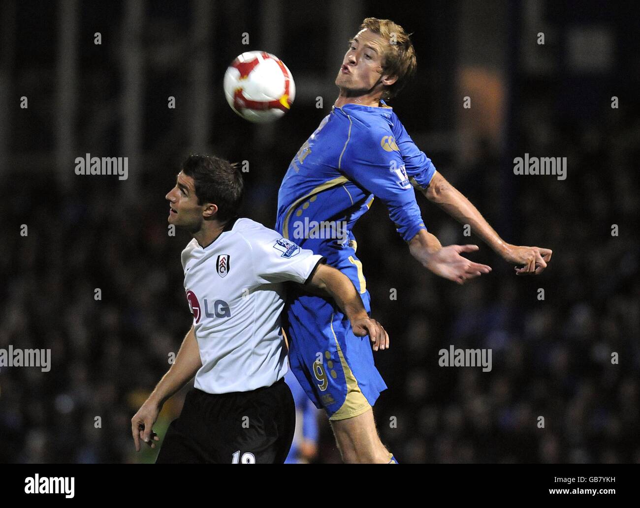 Portsmouth's Peter Crouch (right) and Fulham's Aaron Hughes battle for the ball. Stock Photo