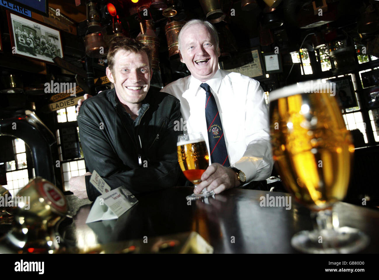 Landlord Gerry O'Brien (right), winner of the Stella Artois Love Your Local campaign and actor Jason Flemyng inside The Churchill Arms on Kensington Church Street, London. Stock Photo