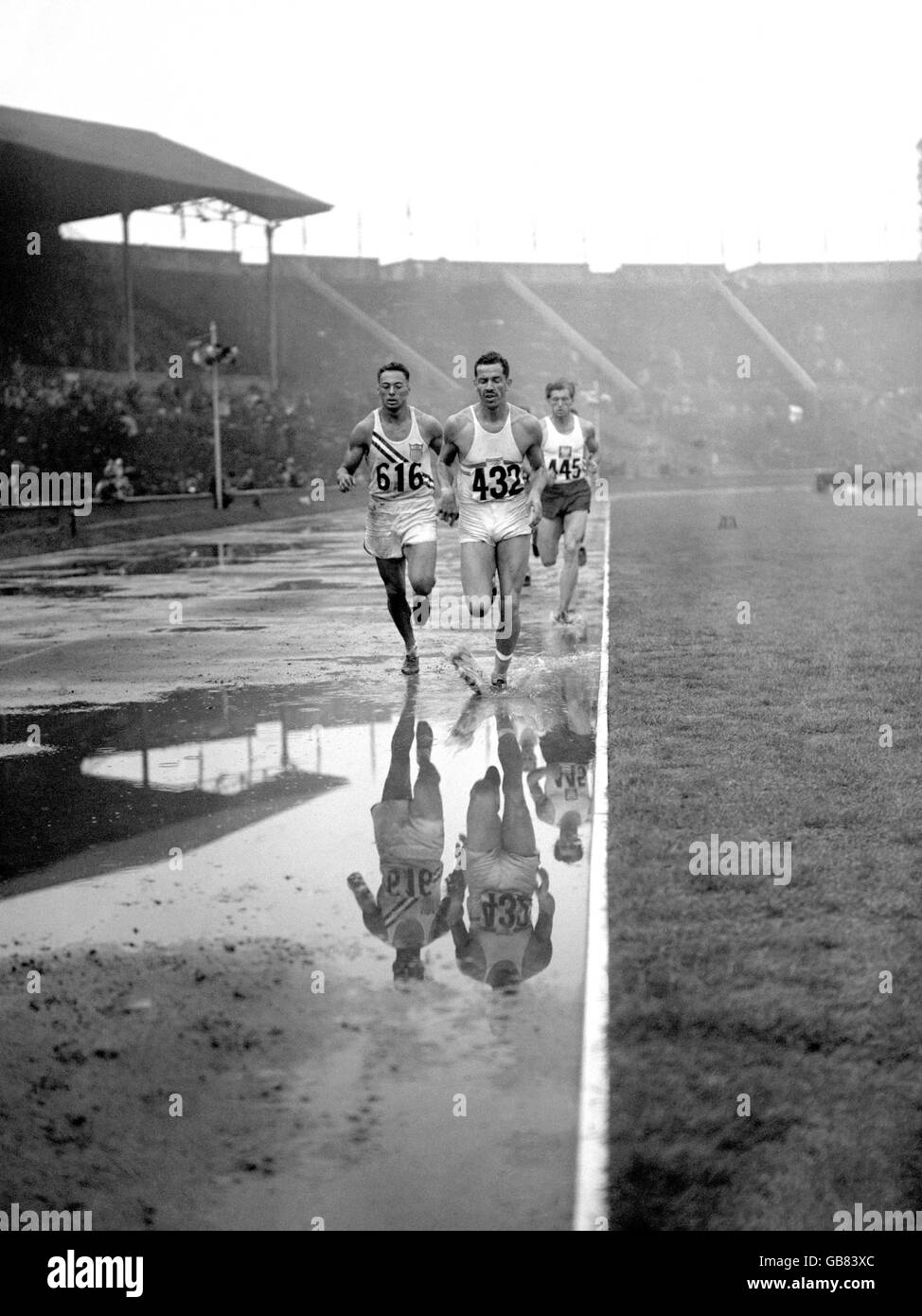 Argentina's Enrique Kistenmacher (432) leads from USA's Irving Mondschein (616) and Poland's Edward Adamczyk (445) as they splash around the track in the 1500m discipline Stock Photo