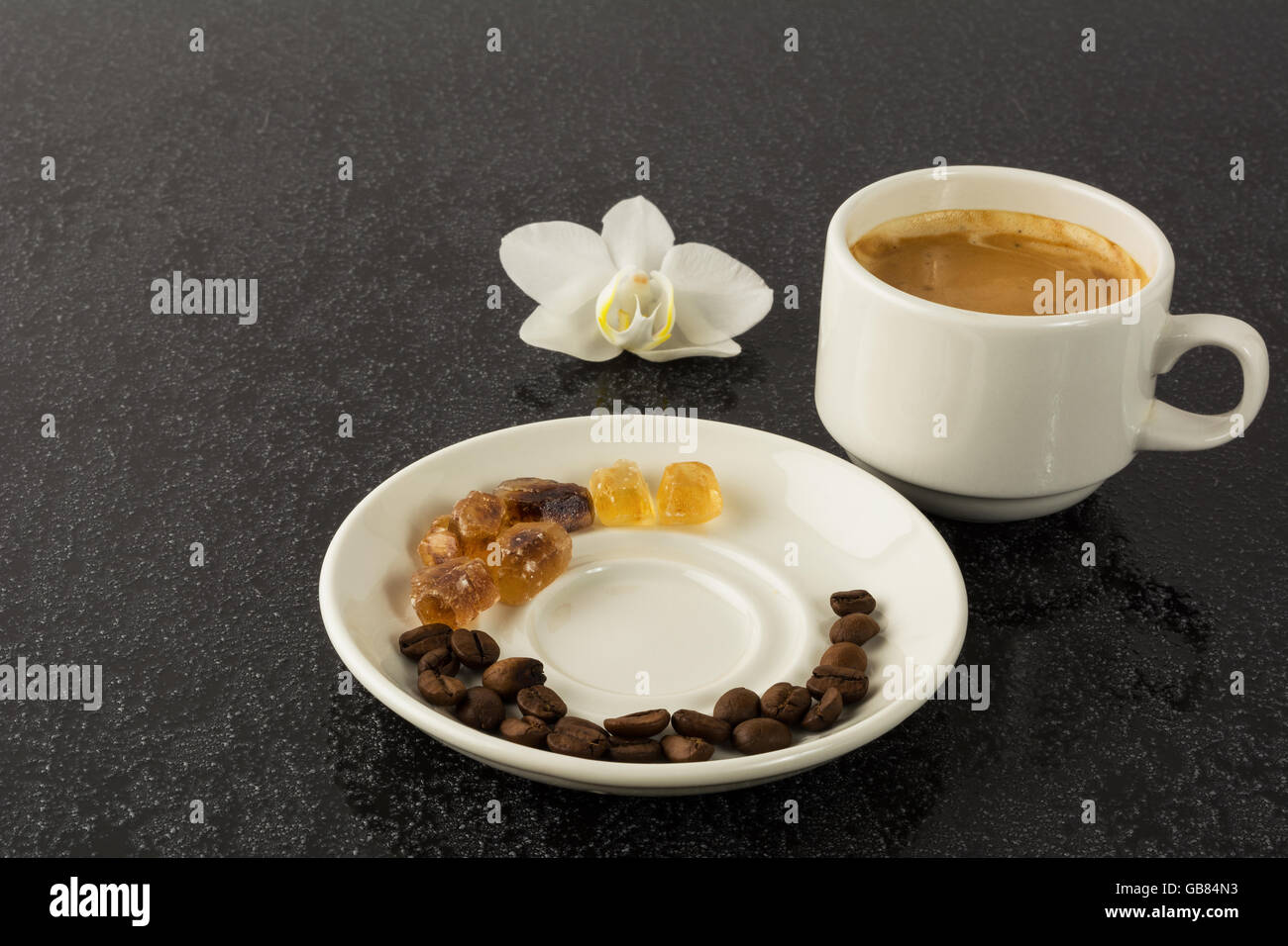 Coffee grains, cup of coffee and orchid. Coffee cup. Strong coffee. Coffee mug. Morning coffee. Cup of coffee. Coffee break. Stock Photo