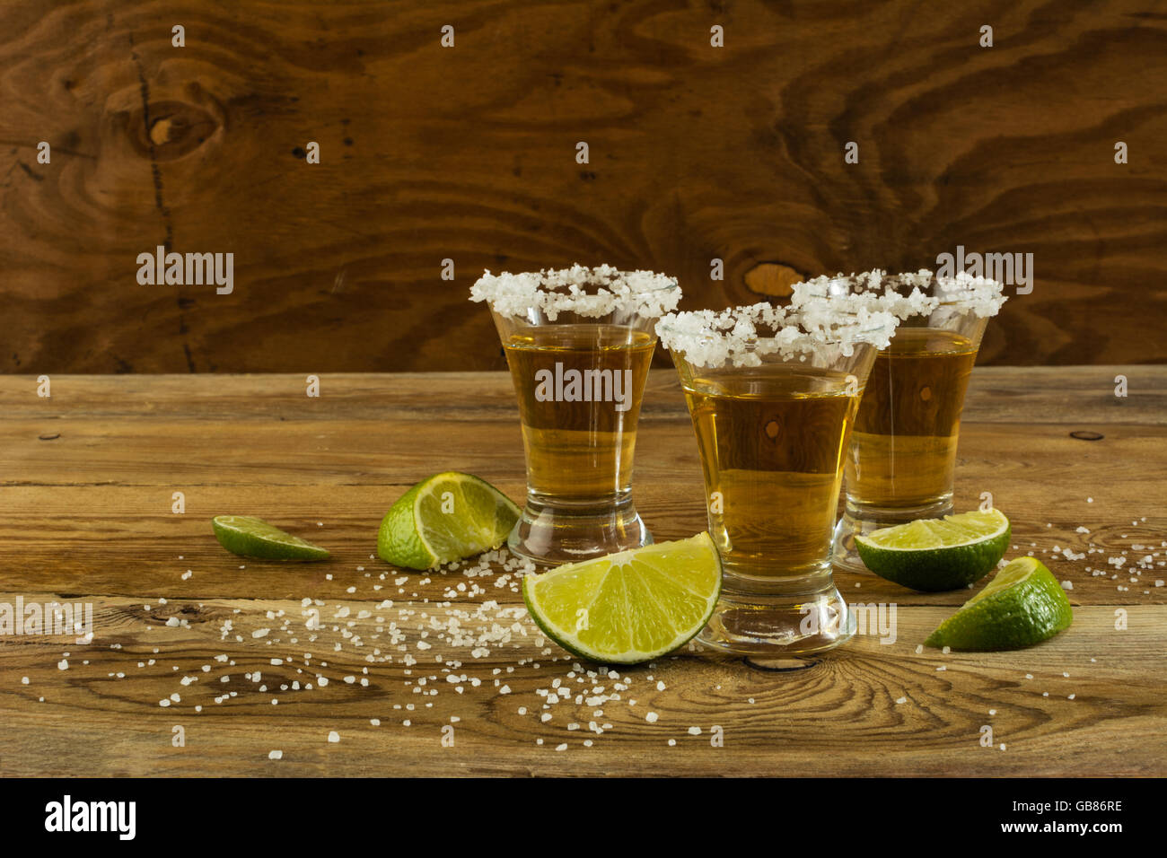 Two gold tequila shots, copy space. Tequila shot. Gold Mexican tequila