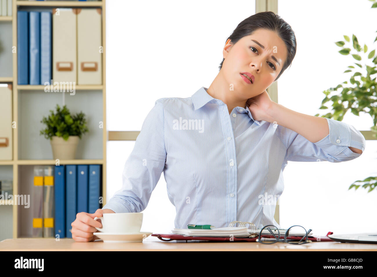 Young asian business woman with pain in neck in office Stock Photo - Alamy