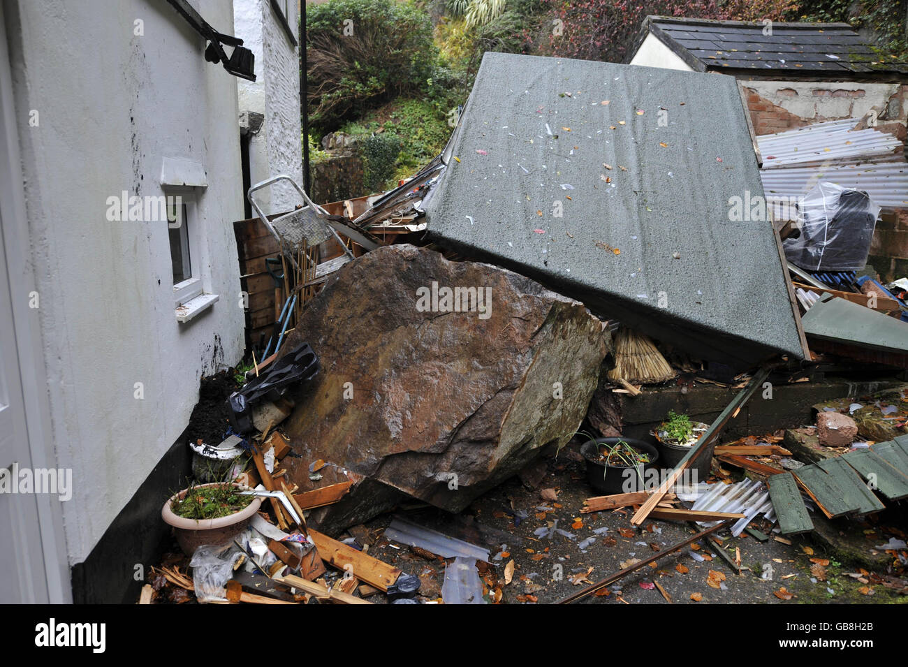A five tonne boulder amongst the remains of Gwyneth Jarman's garden shed at her home in Dulverton, Somerset. Stock Photo