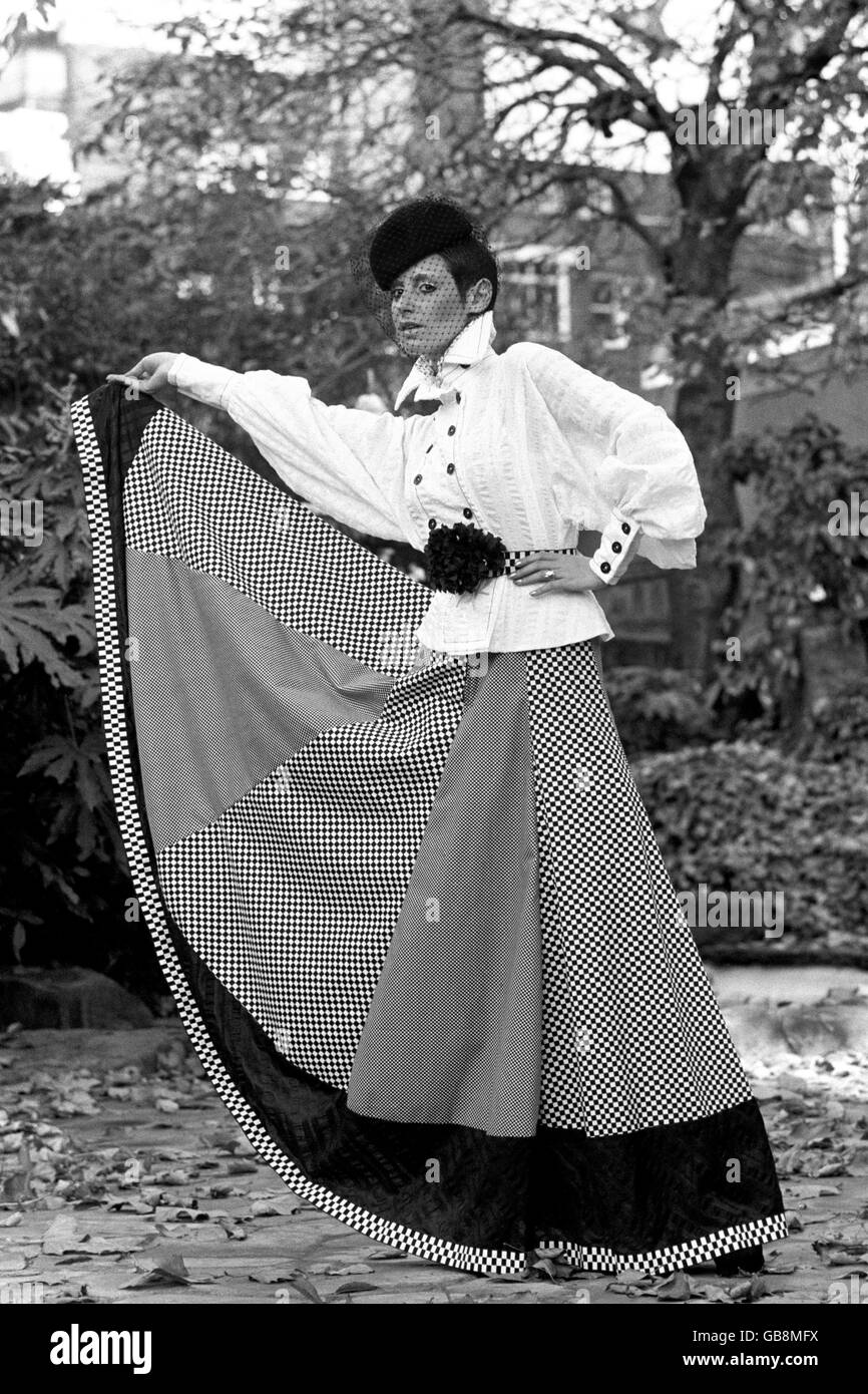 Tica models an outfit from the spring/summer 1973 collection of John Bates. The full-length outfit is made up of black and white check cotton skirt, white cotton blouse and black veiled hat. Stock Photo