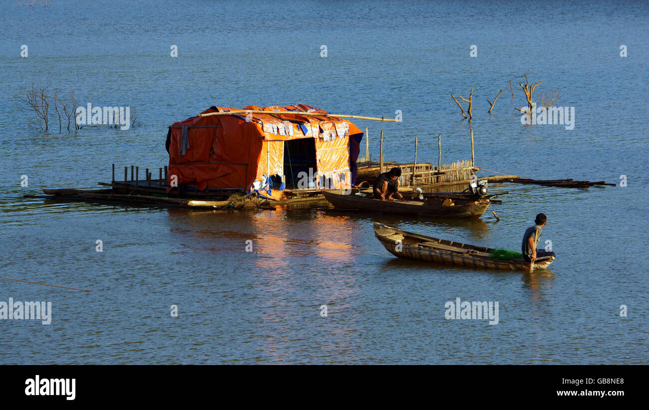 Tranquil,calm scene at evening on fishing village, small thatched house and boat tint by golden light Stock Photo
