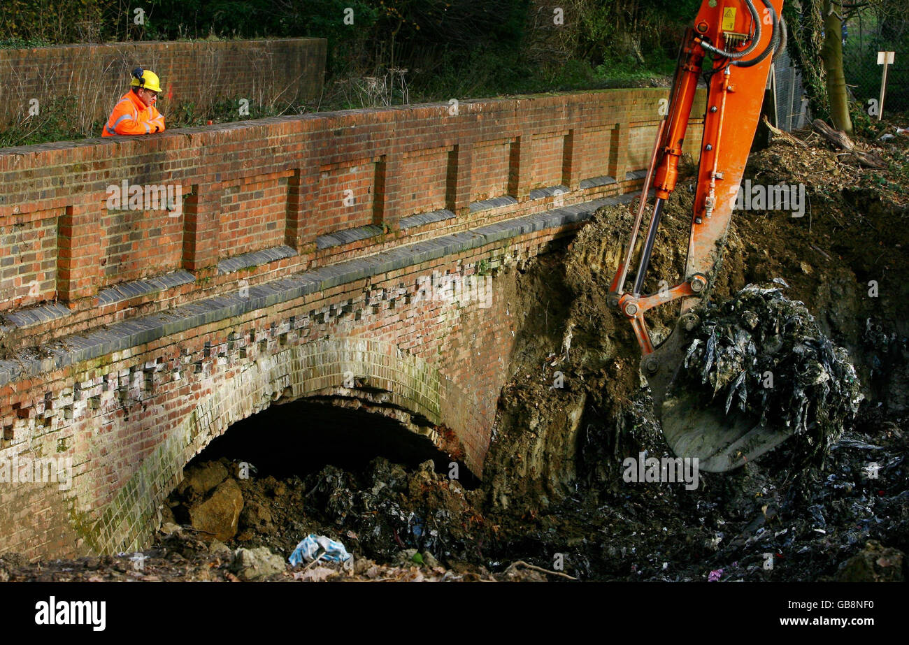 An engineer watches a digger excavate thousands of tonnes of waste