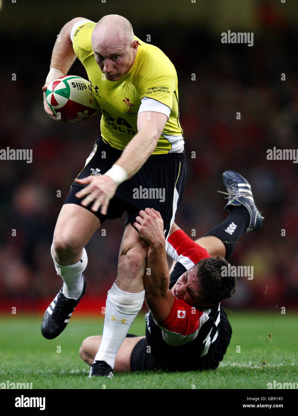 Wales' Tom Shanklin escapes the clutches of Canada's Bryn Keys during the International match at Millennium Stadium, Cardiff. Stock Photo