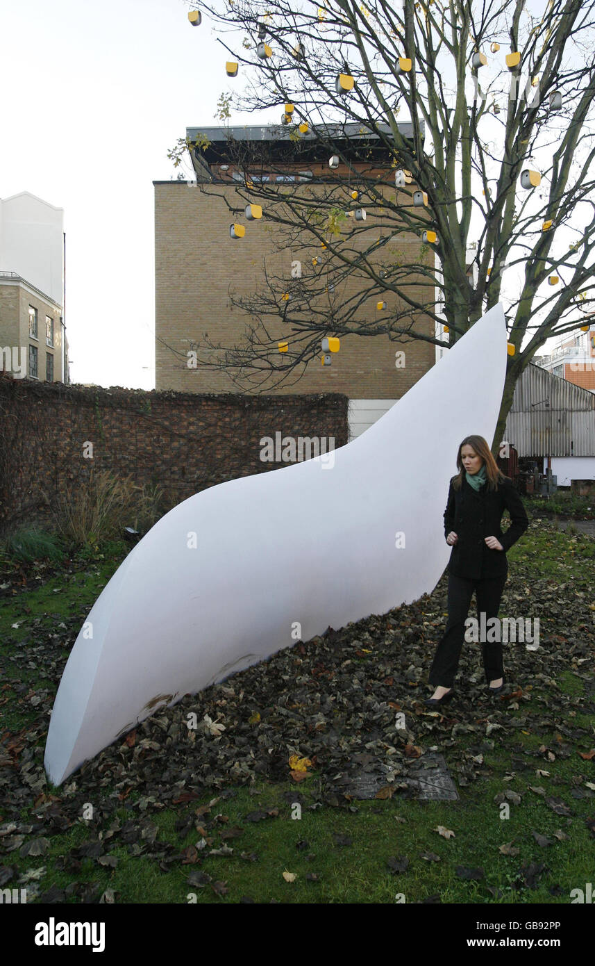 Press officer Sarah Watson walks past Irish sculptor Eilis O'Connell's 'Wingblade', created in Cork, Ireland, employing yacht-making technology and which will go on show as part of a major new exhibition 'Turning the Season' at The Wapping Project in east London, from tomorrow. Stock Photo