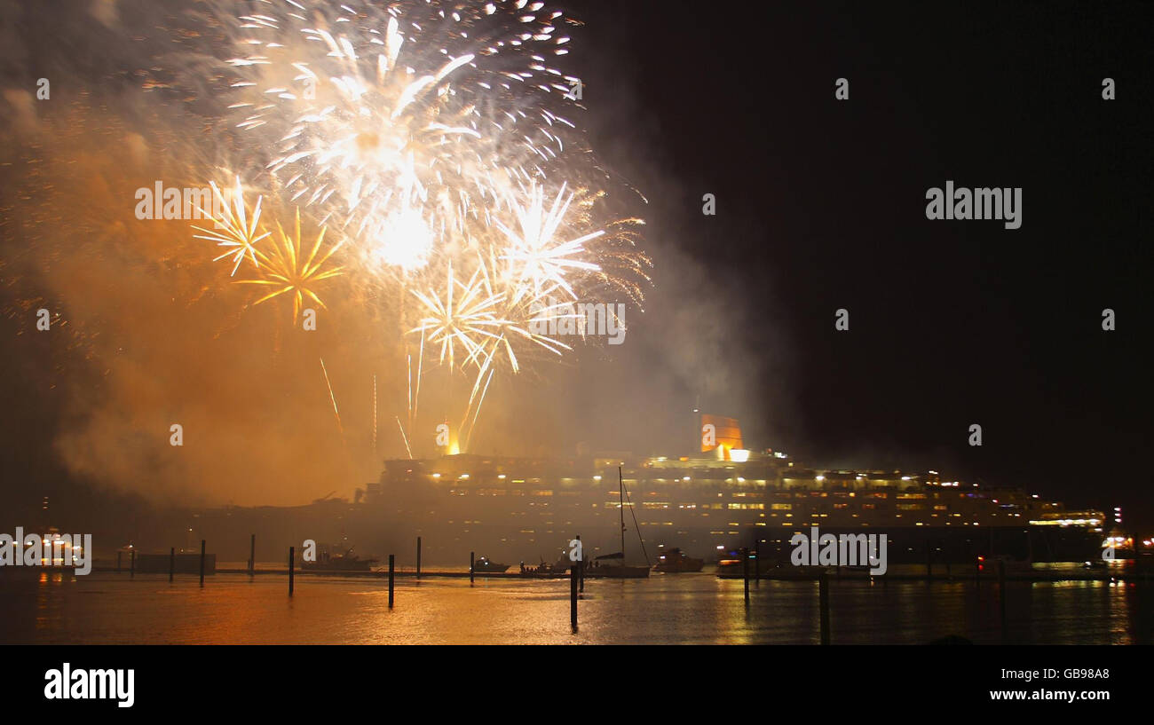 Fireworks explode in the sky as the the 70,000tonne Cunard liner, the