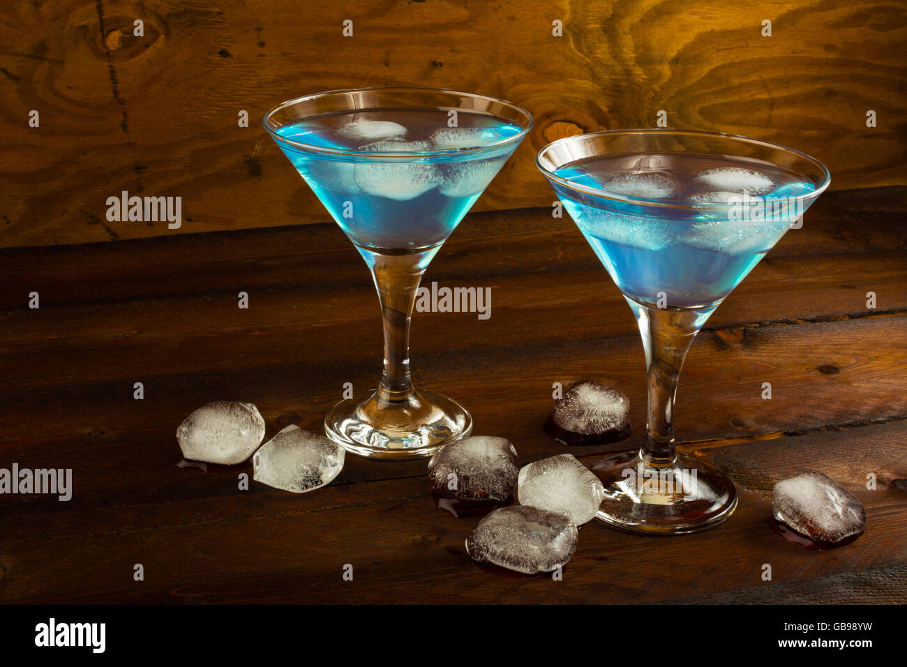 Two glasses of blue cocktail on dark wooden background. Blue Martini