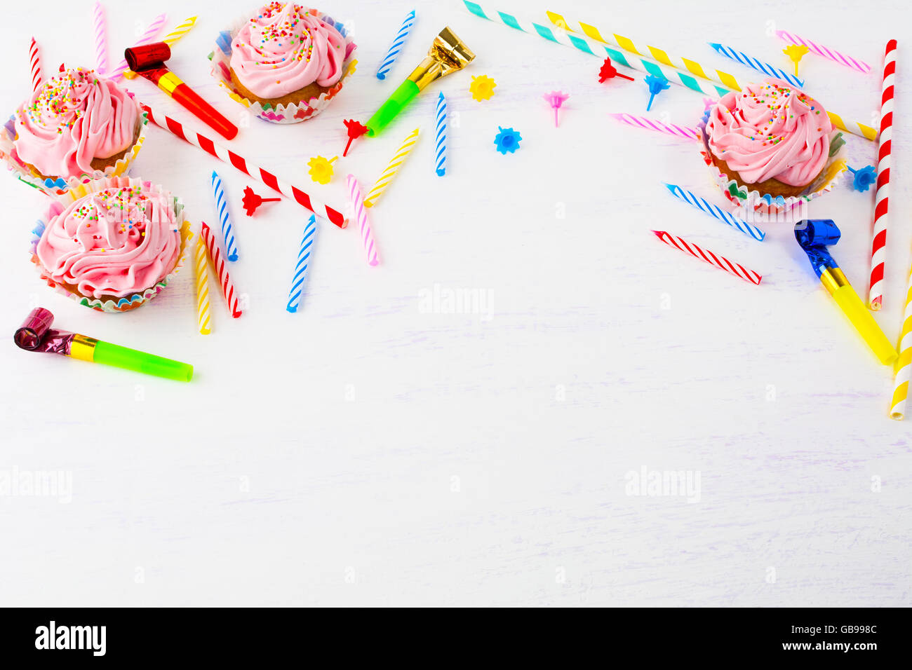 Birthday background with pink cupcakes and candles. Birthday cupcakes. Gourmet cupcakes. Sweet dessert. Sweet pastry. Stock Photo