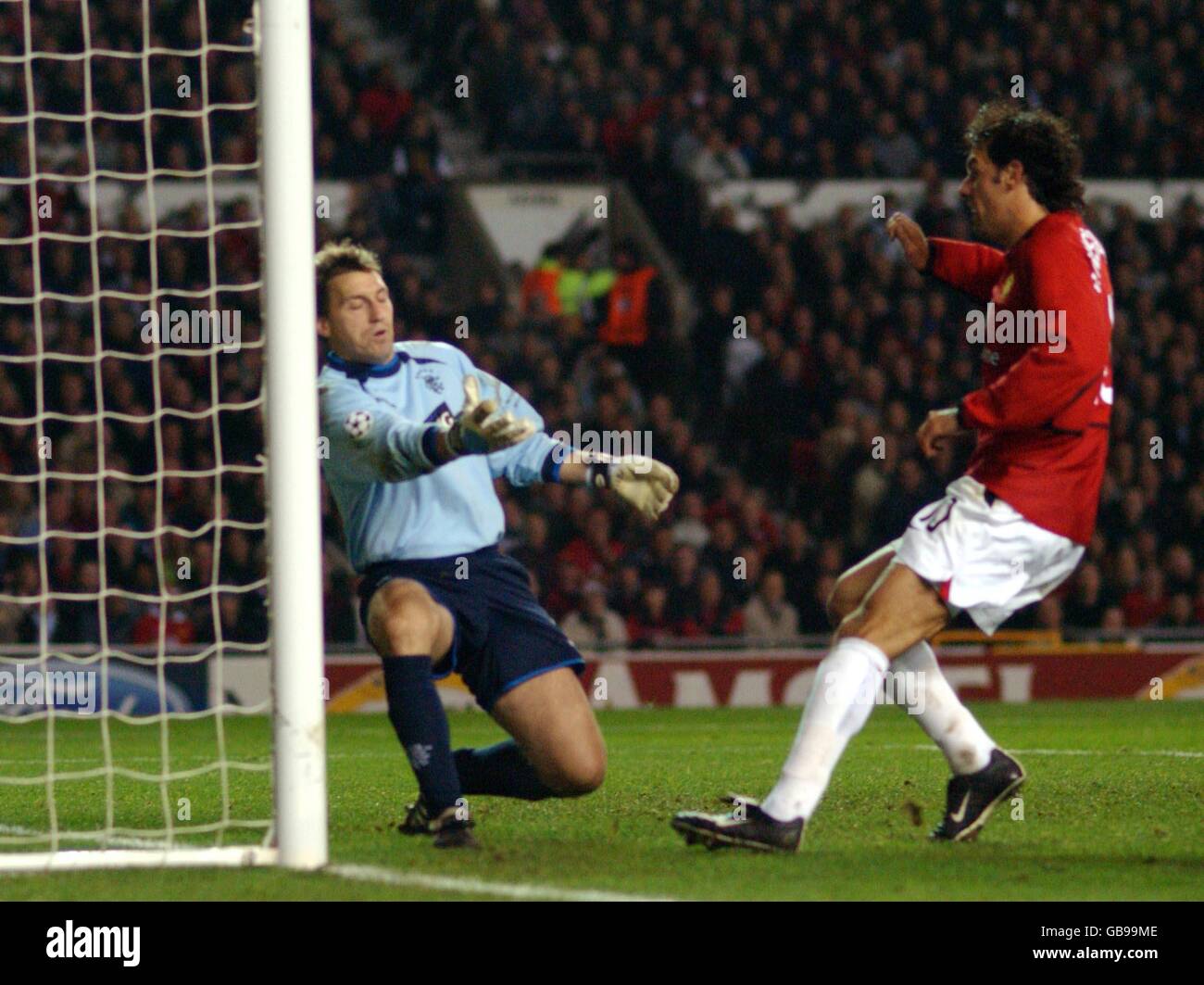 Soccer - UEFA Champions League - Group E - Manchester United v Rangers. Manchester United's Ruud van Nistelrooy scores their third goal past Rangers' goalkeeper Stefan Klos Stock Photo