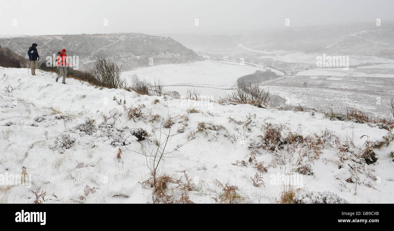 Walkers in the snow at the Hole-of-Horcum in the North Yorkshire Moors National Park as an arctic weather front hits the UK. Stock Photo