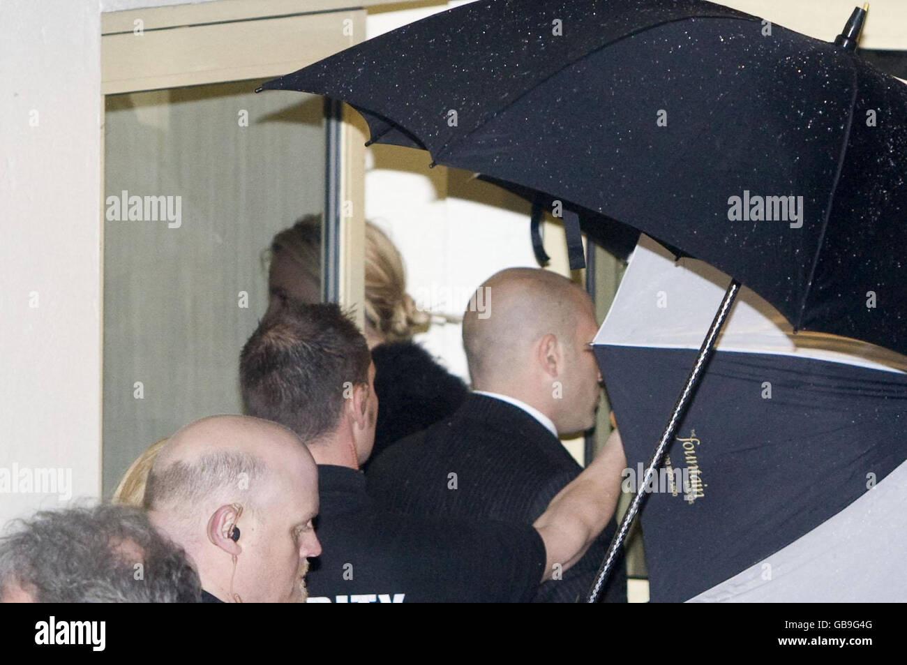 Pop singer Britney Spears arrives at Fountain Studios in Wembley, London, shielded by umbrellas as she arrives for her X Factor performance. Stock Photo