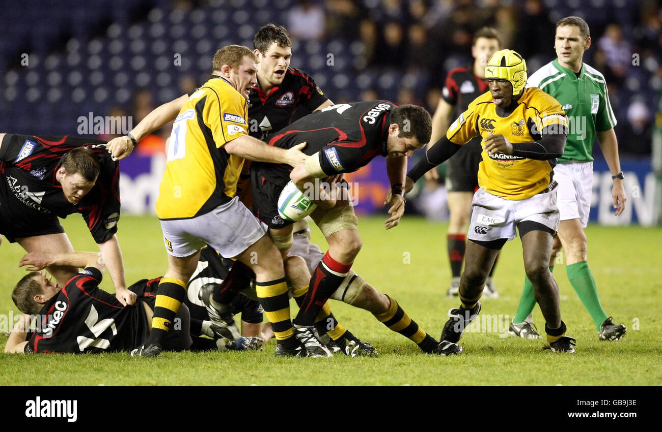 Edinburgh's Jim Hamilton breaks through a tackle from Wasps captain Phil Vickery (left) and Serge Betsen (right) during the Heineken Cup match at Murrayfield Stadium, Edinburgh. Stock Photo