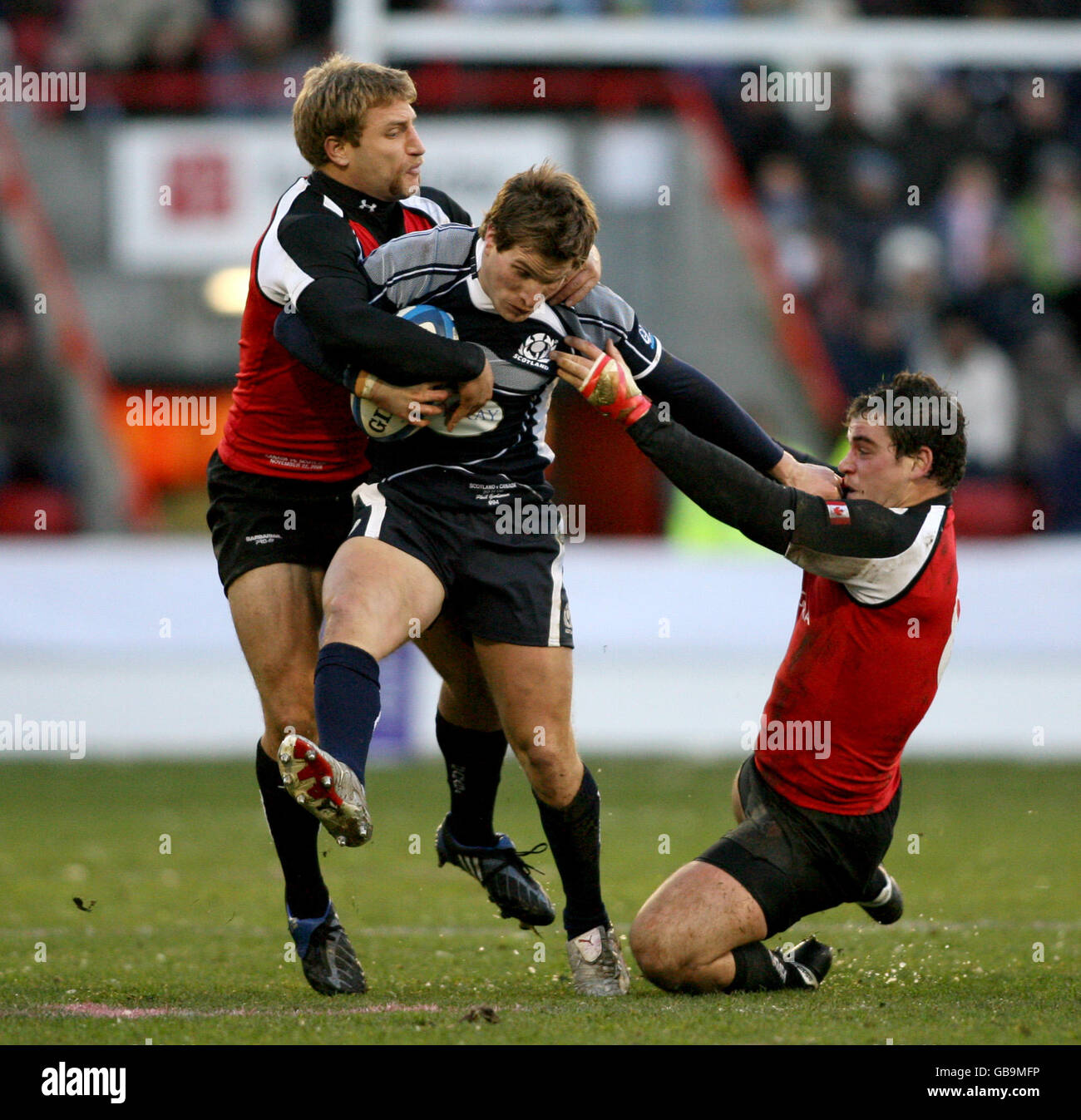 Scotland's Phil Godman is tackled by Canada's Adam Kleeberger and Aaron Carpenter. Stock Photo