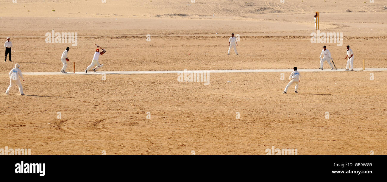 Local cricket teams play a match in the desert outside the Sheikh Zayed
