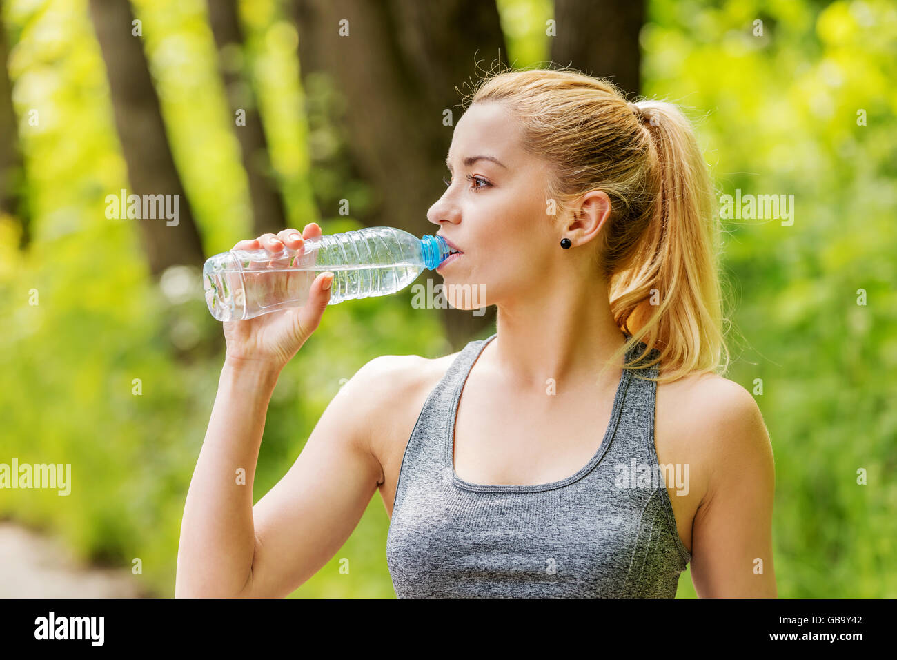 Sporty woman drinking water. Stock Photo